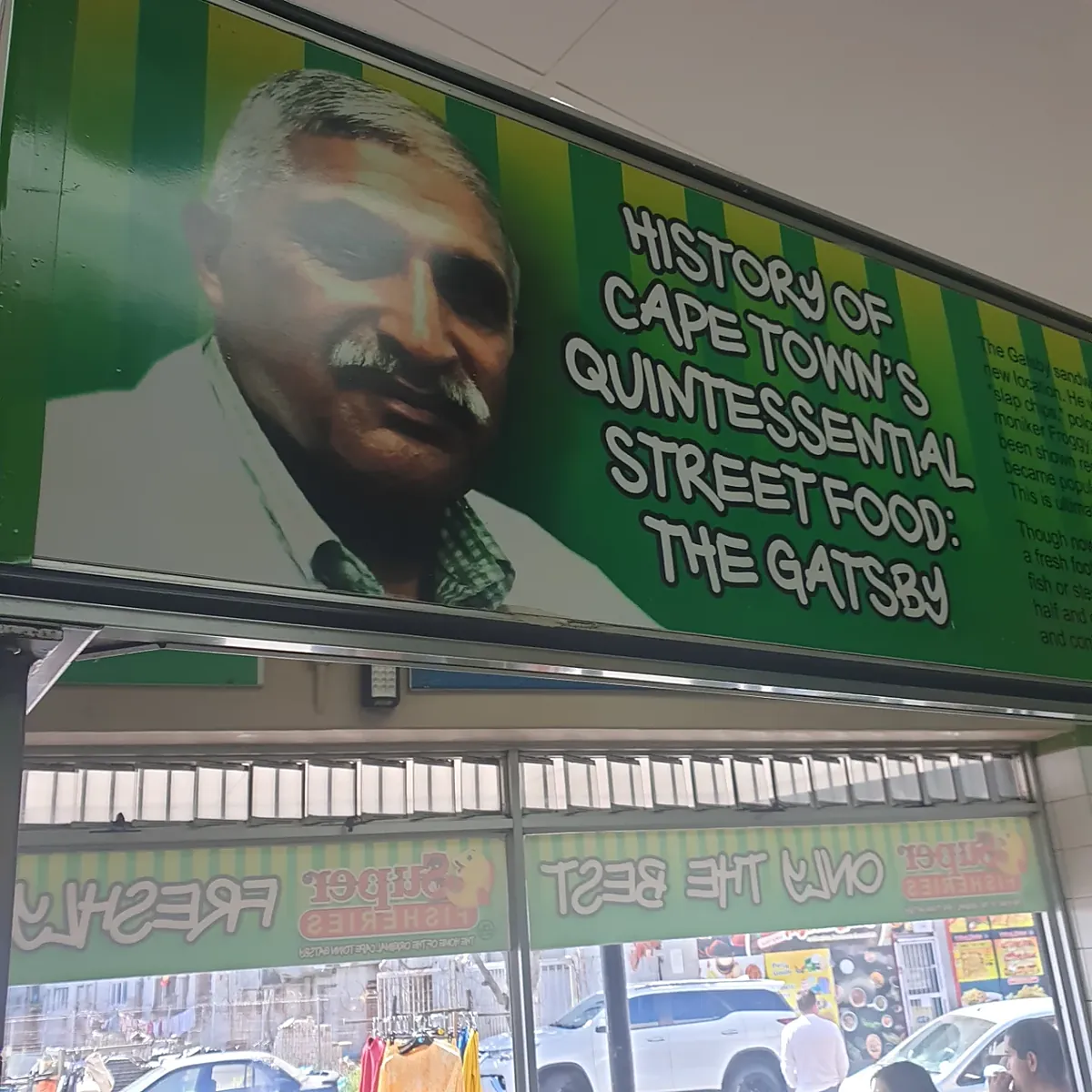 The history panel above the counter at Super Fisheries, with Rashaad Pandy's portrait and the heading 'History of Cape Town's quintessential street food: The Gatsby'.