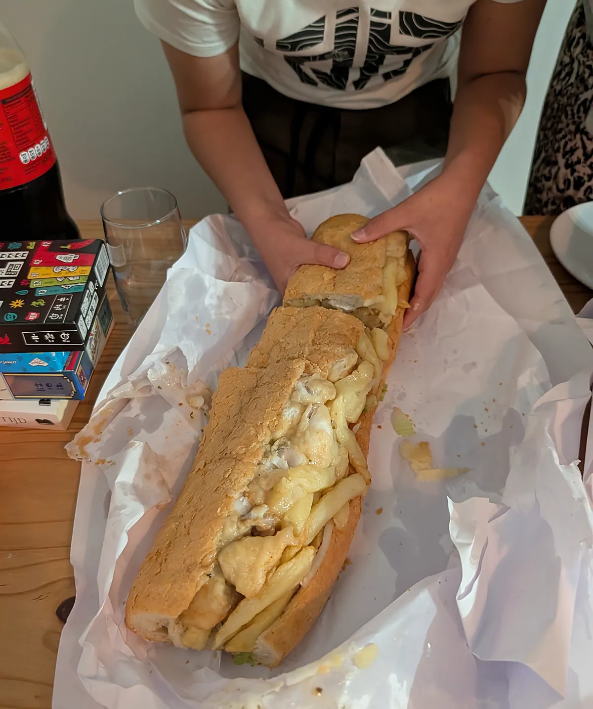 Hands unwrapping a long Super Gatsby from its paper.
